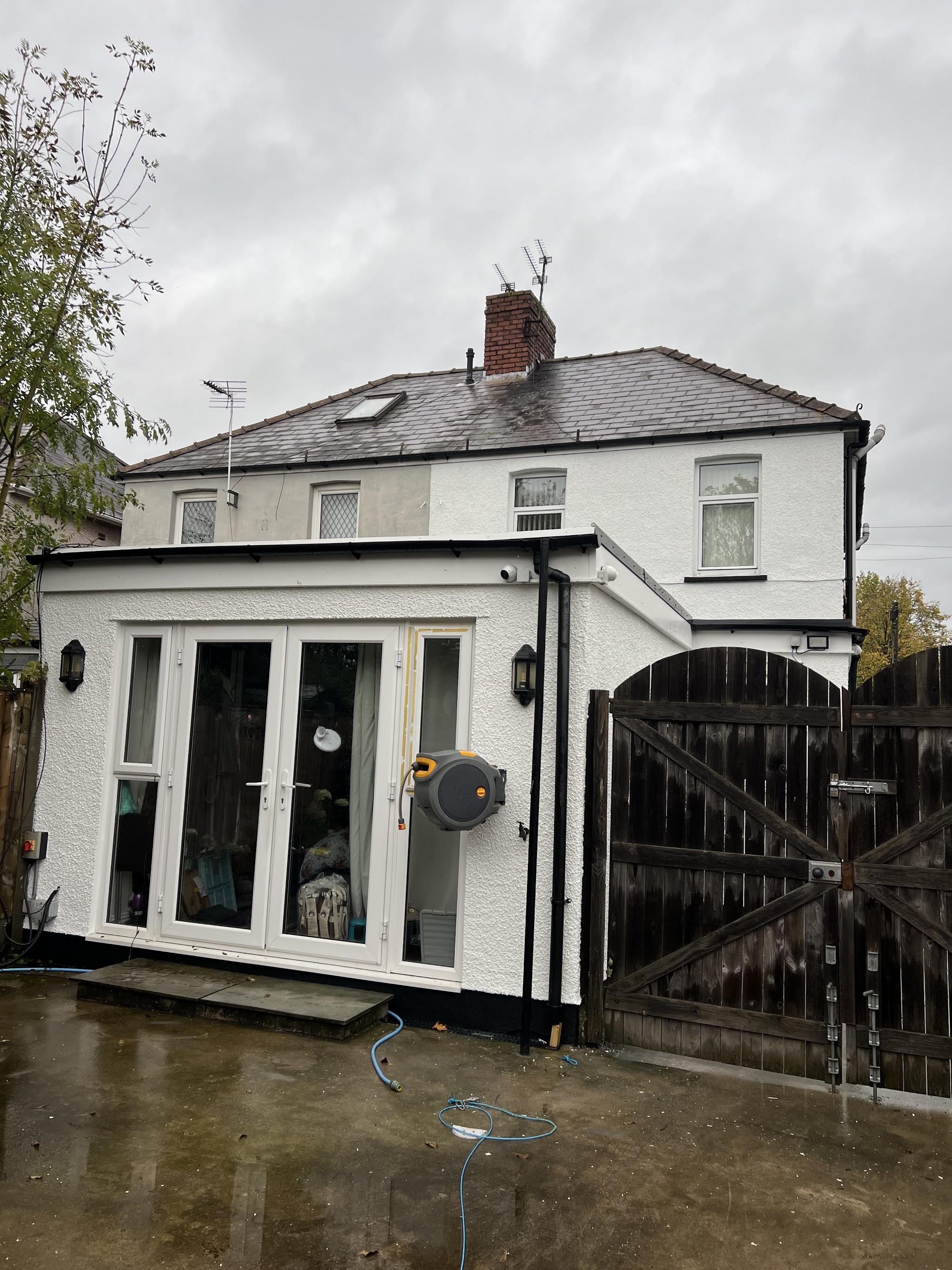 Rear extension finished in white render with a black plinth and French doors